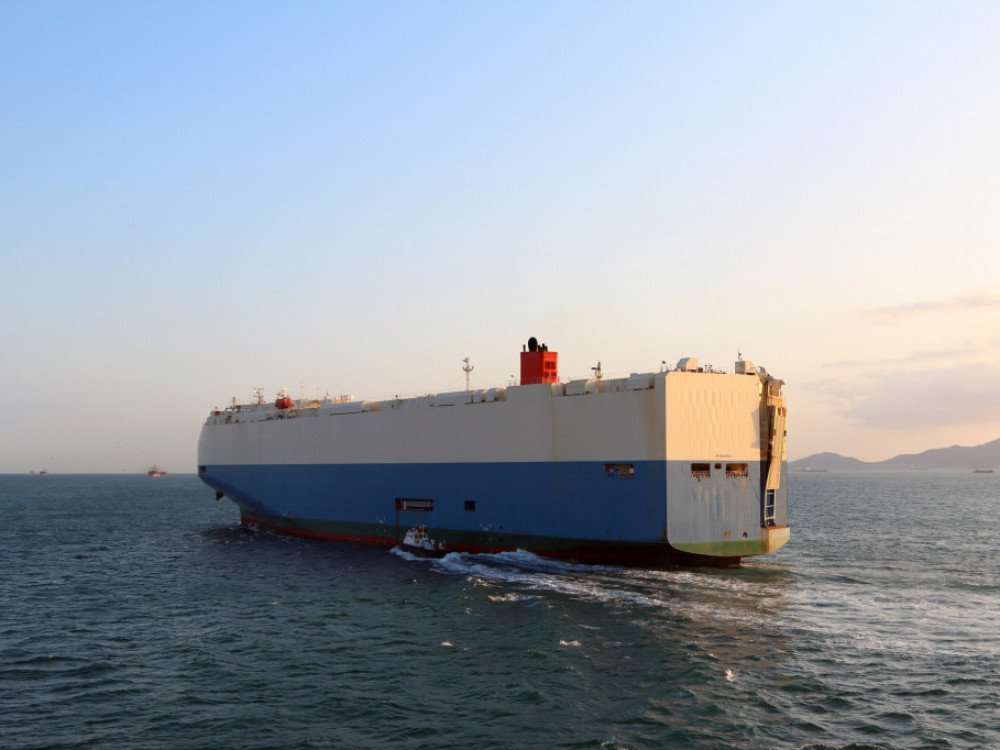 Ladja z vozili BMW-ja in Mercedesa bo verjetno gorela še več dni